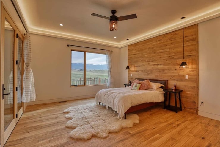 Modern farmhouse-style bedroom in Sheridan, WY custom home build with view of mountains through window-1