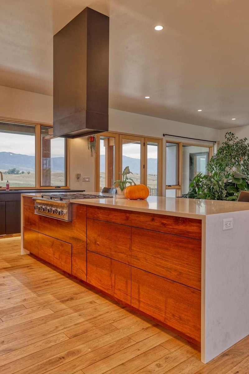 Modern farmhouse-style island with flat panel storage and cooktop in Wyoming custom home