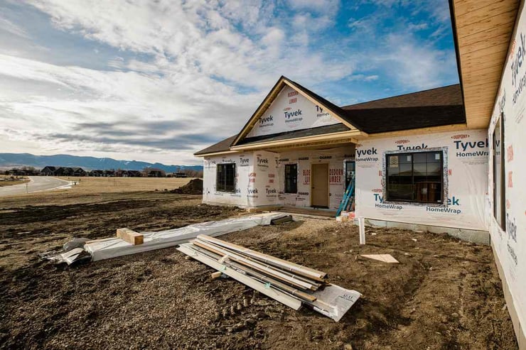 Construction materials in front of new home being built with Wyoming landscape in background