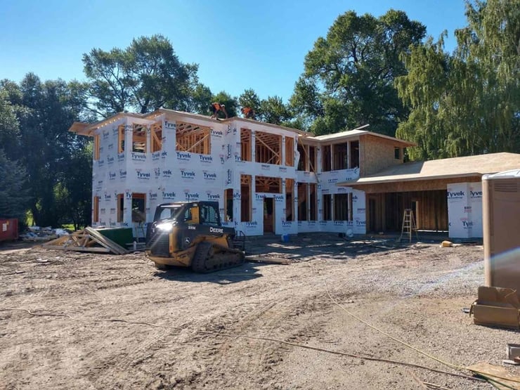 New home construction exterior view with foundation and framing