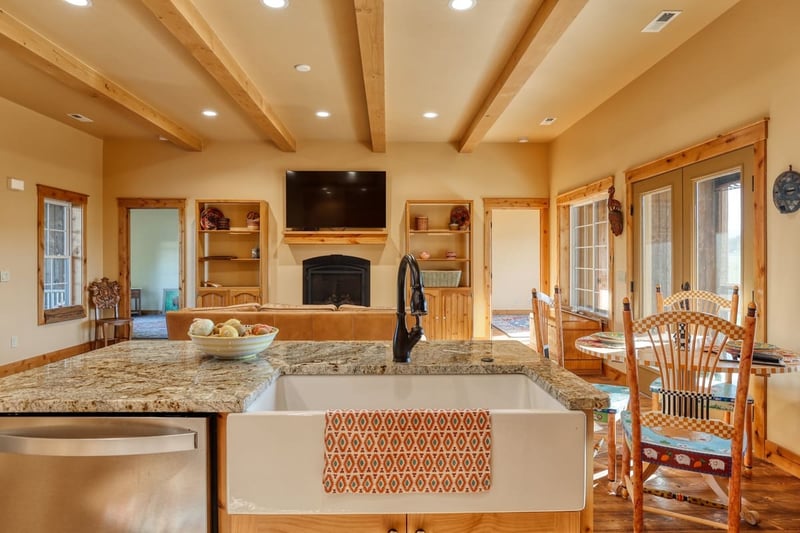 View of main floor in Wyoming custom home from porcelain farmhouse sink with black faucet