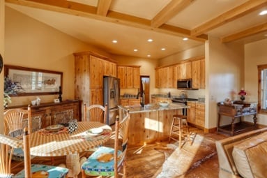 Open-concept craftsman-style kitchen and dining area with wood ceiling beams-1