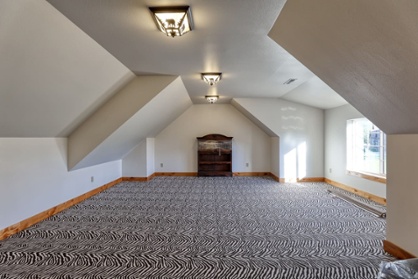Room in custom home with angled ceiling and pattern carpeting-1