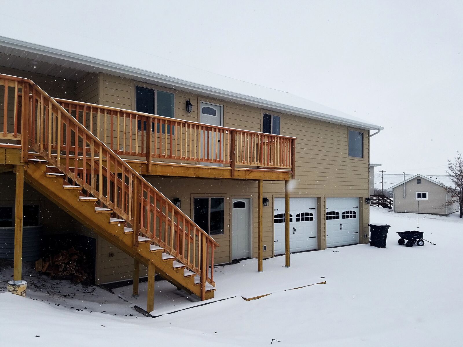 custom home exterior with deck during snow storm in wyoming