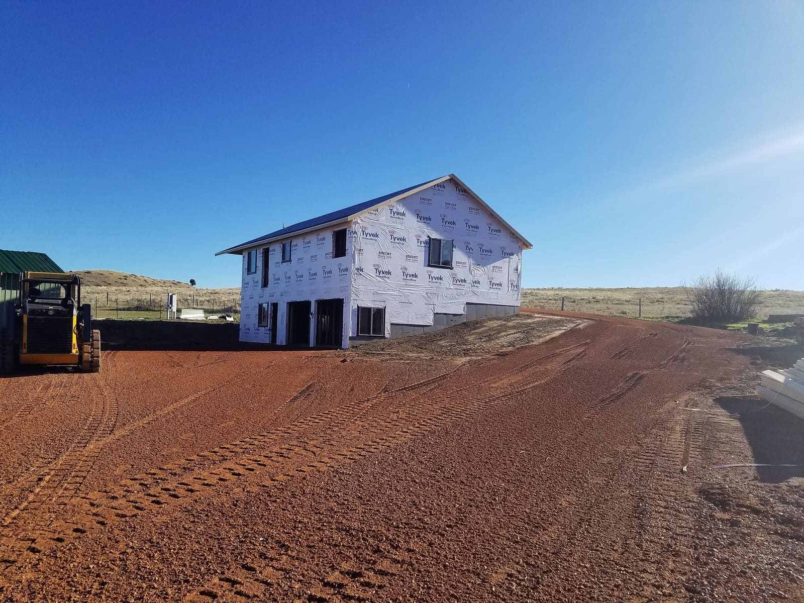 New construction exterior during day with framing and wrapping