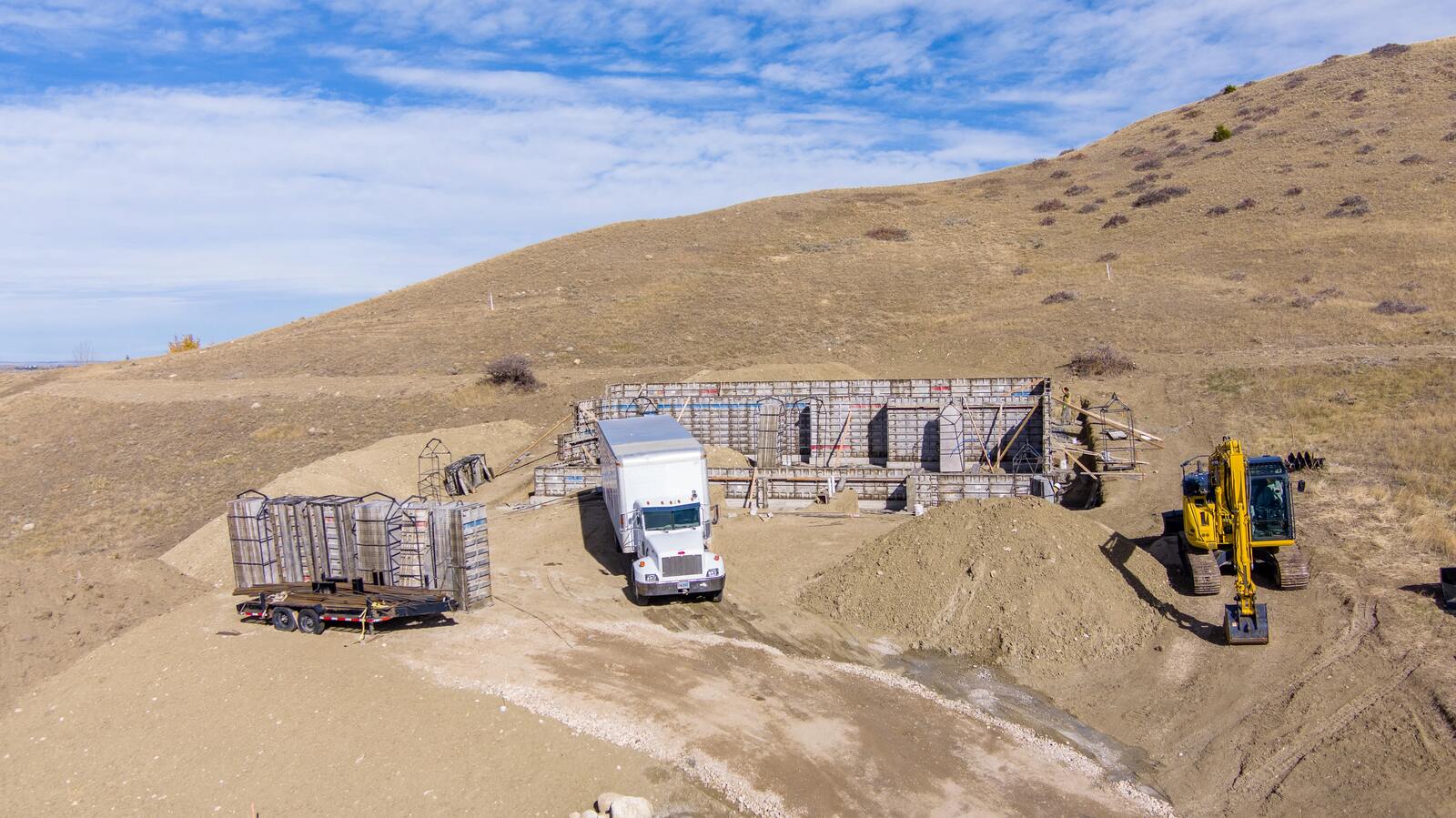 custom home being built with truck and equipment in wyoming