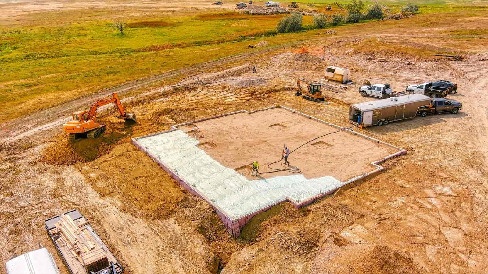 Aerial shot of two home builders laying foundation for custom home