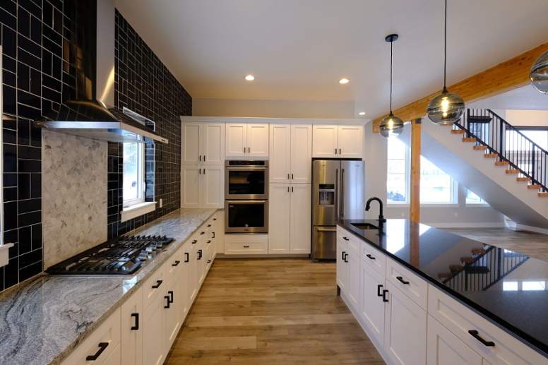 modern-kitchen-in-custom-home-with-extended-island-and-white-cabinetry-2