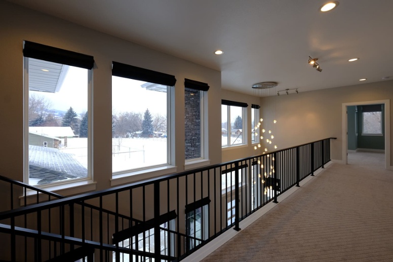 second-story-hallway-of-custom-home-with-black-railing-on-side-1