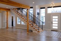 wood-staircase-and-black-railing-in-foyer-of-new-home-build-1