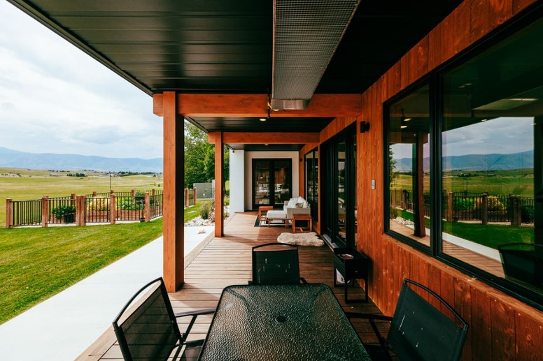 View of back deck on Wyoming custom home with outdoor table and wood porch posts-1