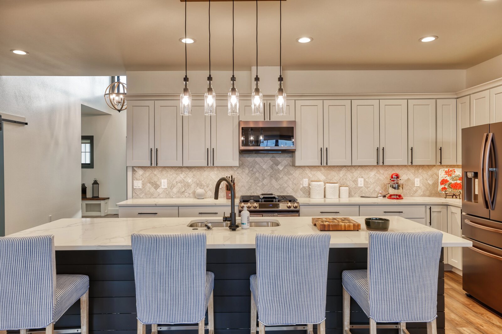 custom home kitchen with pendant lighting bar chairs at island and tiled backsplash in wyoming