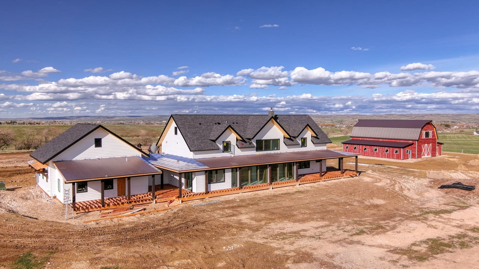 Custom home exterior with wrap-around porch and barn