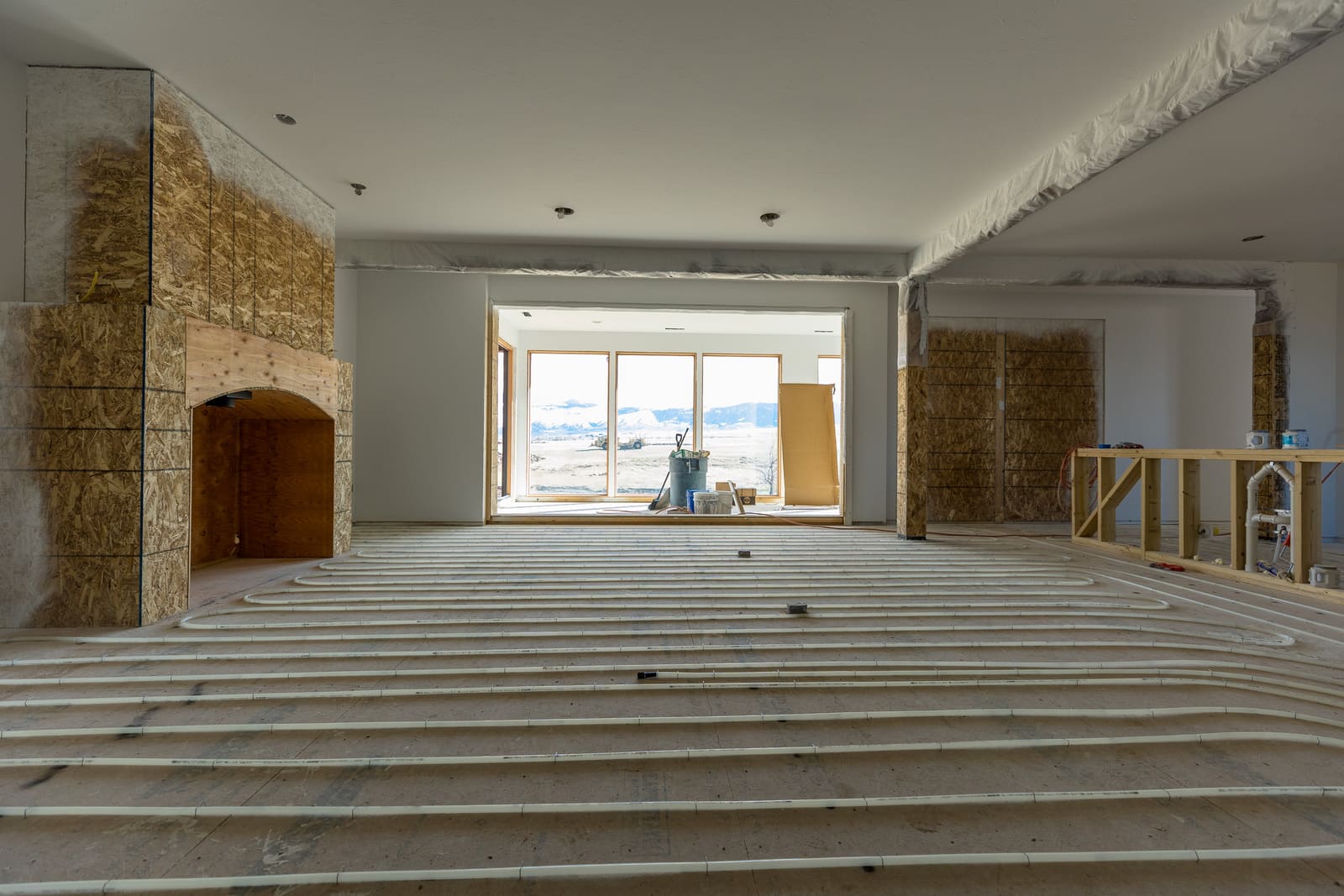 Custom home flooring installation with fireplace being built