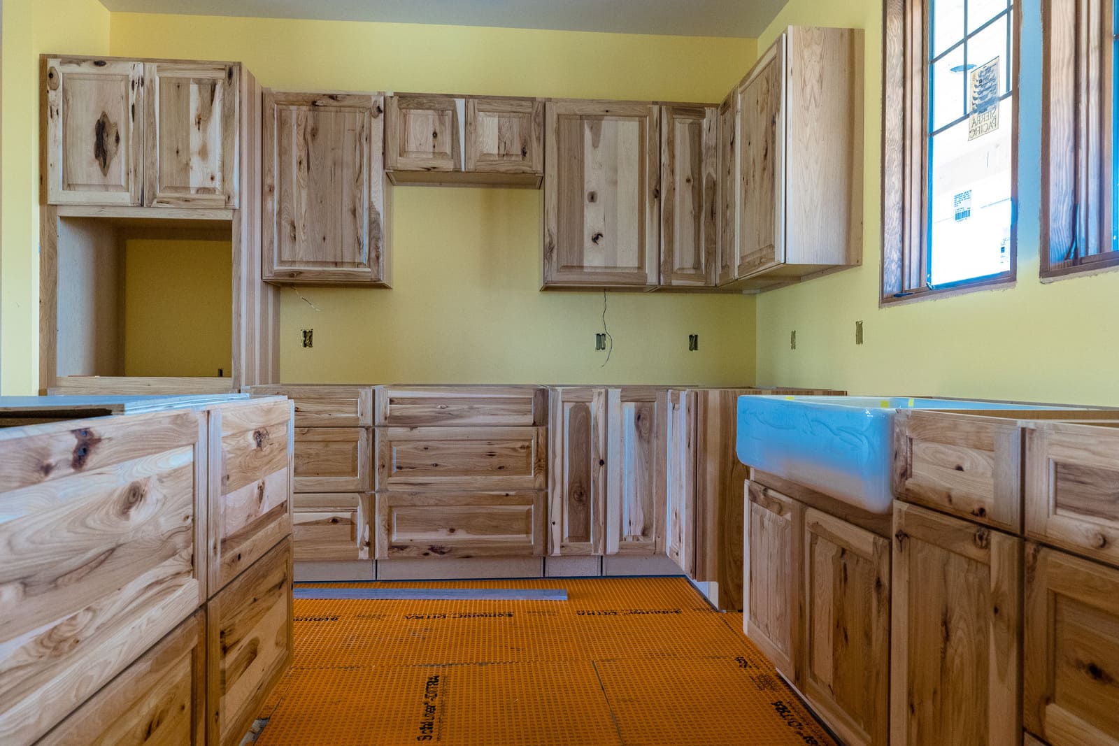 Custom pine wood kitchen cabinetry with sink installed
