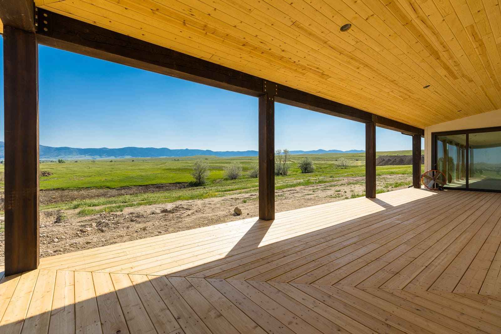 Custom wrap-around porch with view of Wyoming landscape