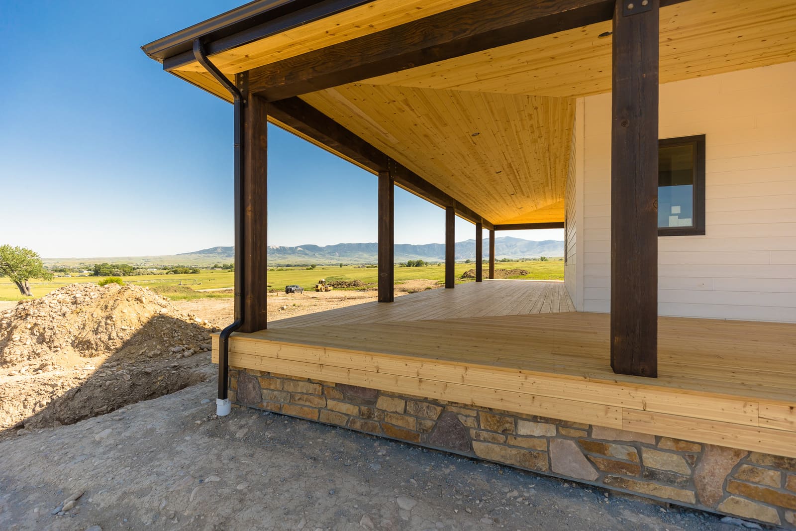 Stone veneer under custom wrap-around porch on new build