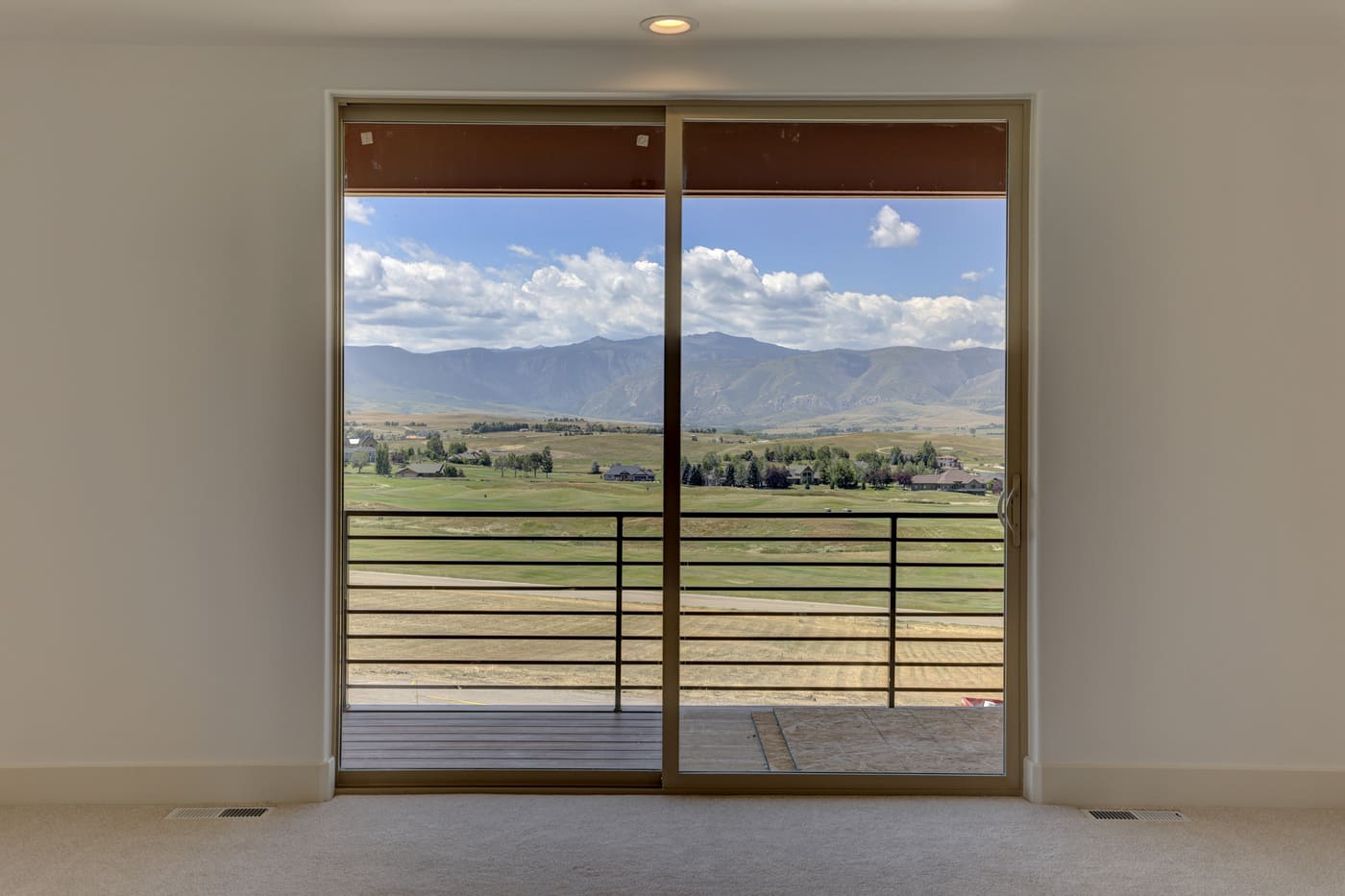 View of sliding glass door of Wyoming custom home with view of mountain landscape