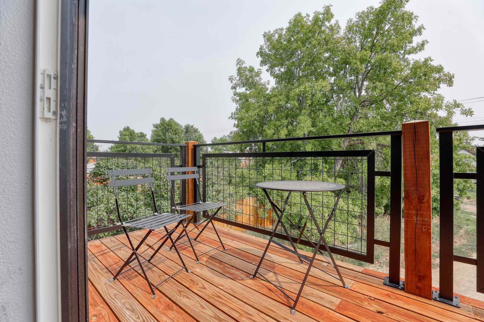 wood balcony with chairs and table in wyoming custom home