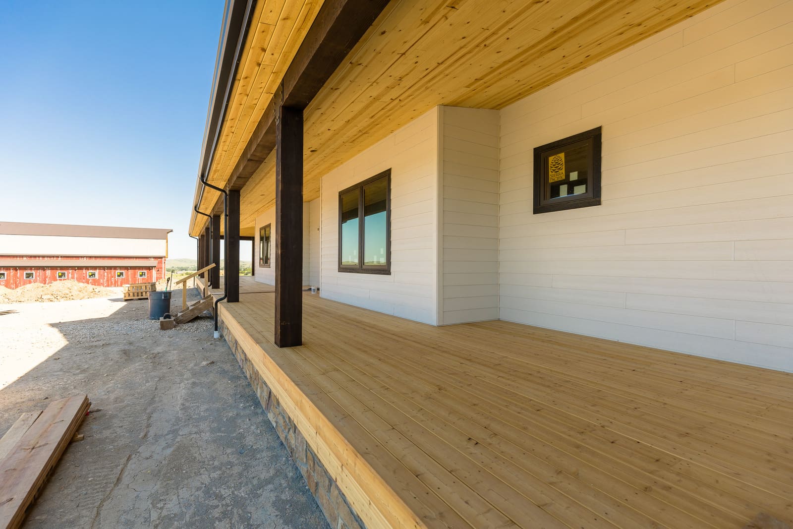 Wrap-around porch construction progress with dark wood posts